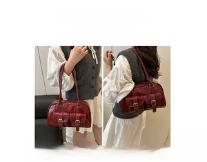 Detail of burgundy glossy retro bowling bag with double buckle pockets and shoulder strap