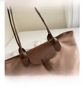 Dettaglio della borsa tote in tessuto oxford con zip e contrasto dei manici in pelle