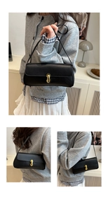 Detail shot of black litchi pattern leather bag with a geometric golden metal buckle