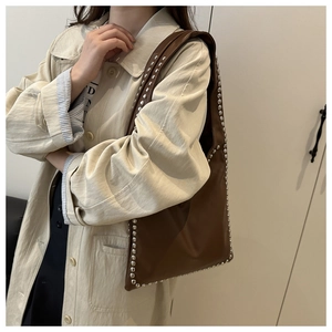Detail shot of the vintage brown shoulder bag showing silver rivet studs and leather texture