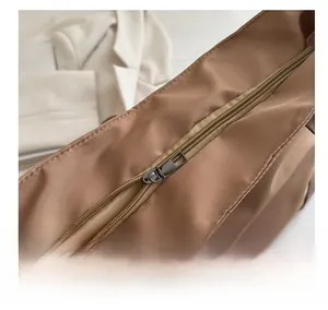 Dettaglio della cerniera fluida sulla borsa tote in nylon kaki da donna elegante