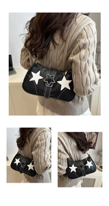 Detail view of black underarm bag with white star applique and star metal buckle