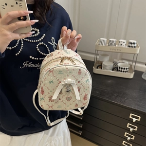 Cute cream mini backpack with cartoon bear prints and decorative white bow and heart charm
