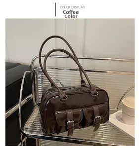 Close-up of brown glossy patent leather Boston bag with decorative silver buckle pockets