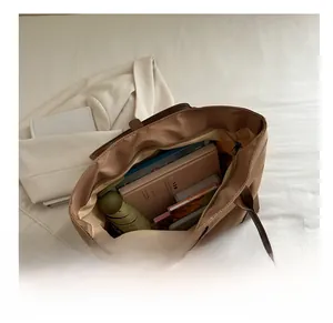 Vista interna dettagliata di una grande borsa tote in nylon marrone con libri e ombrello