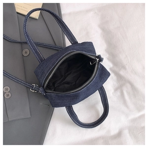 Close-up of vintage denim mini bag showing silver zipper and interior lining details