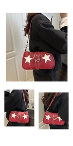 Detail of red shoulder bag featuring white star patches and contrast stitching details
