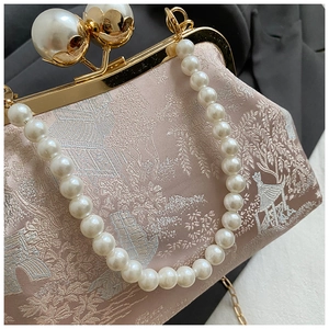 Nahaufnahme der Blumenstickerei und des Perlengriffs an der Vintage-Muscheltasche