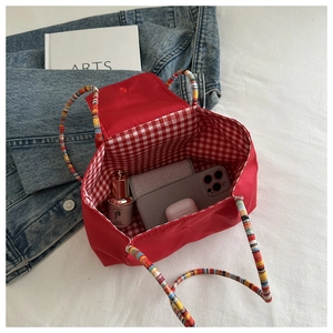 Détail du sac cabas en nylon rouge avec doublure à carreaux et grande capacité interne