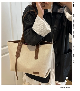 Detail of canvas tote bag with brown leather trim and fashion patch in macro view