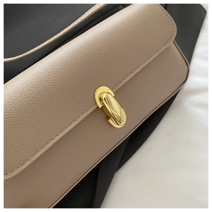 Detail of lychee pattern leather bag with a polished golden oval swivel lock