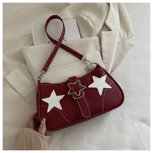 Detail of burgundy baguette bag featuring white star patches and star-shaped metal buckle