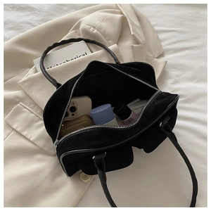 Détail du sac à bandoulière en daim noir avec deux poches frontales et intérieur spacieux