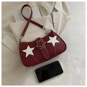 Detail der weinroten Handtasche mit Sternmuster, Lederstruktur und Smartphone-Größenvergleich