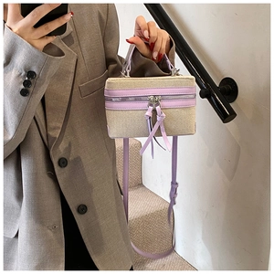 Detail of beige canvas and lavender leather stitching on boxy shoulder bag with strap