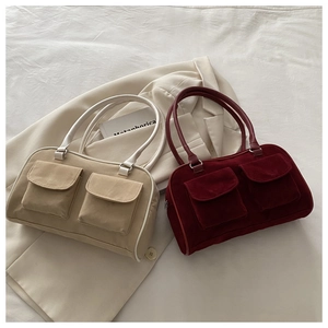 Détail de sacs à main vintage beige et rouge avec deux poches à rabat sur un lit doux