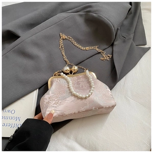 Detail der rosa Blumenstickerei und Perlenhandgriff an einer Retro-Rahmenhandtasche