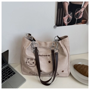 Détail du sac fourre-tout en nylon beige avec motif chat et bandoulière en chaîne