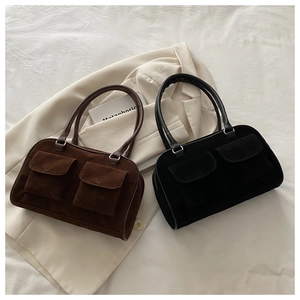 Détail de sacs bandoulière en suédine marron et noir avec poches à rabat symétriques