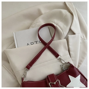 Detail der weinroten Lederschultertasche mit weißen Stern-Patches und Kontrastnähten