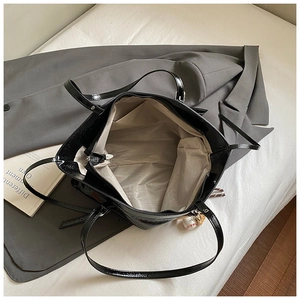 Detailed top view of black glossy tote bag showing interior lining and compartments