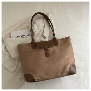 Dettaglio della borsa tote in nylon kaki con manici in pelle marrone e angoli rinforzati