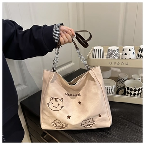 Détail du grand sac cabas en nylon crème avec imprimé chat et poignée en chaîne