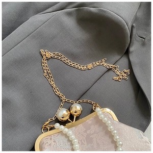 Nahaufnahme von Perlengriff und Goldrahmen an der bestickten floralen Abendtasche