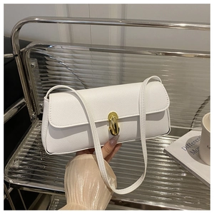 Detail of white lychee leather texture and golden metal rotary buckle on the handbag