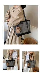 Detail of grey vintage tote bag showing fabric texture, black leather trim and fashion label