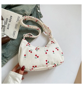 Detail der weißen Cord-Hobo-Tasche mit Kirschmuster und verstellbarem Schultergurt