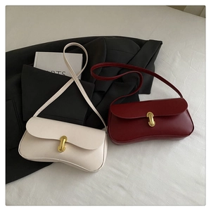 Detail of elegant shoulder bags with golden clasps in cream white and deep burgundy colors