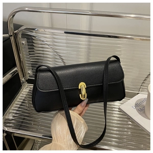 Close-up of black lychee texture leather underarm bag featuring a gold oval twist lock