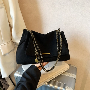 Chic black suede crossbody bag with gold chain strap and metal hardware detail