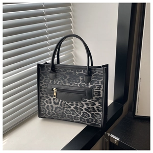 Dettaglio della borsa leopardata con bordo nero e tasca funzionale con zip dorata