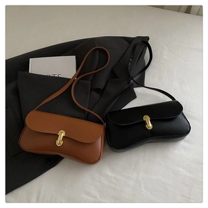 Detail view of retro shoulder bags in black and brown with gold U-shaped metal buckles