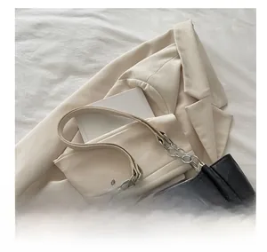 Detail view of black tote bag with checkered pattern and elegant metal chain strap
