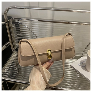 Close-up of beige lychee leather texture and golden rotating buckle on shoulder bag