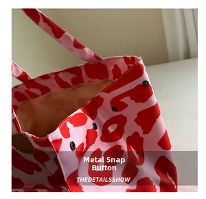 Detail shot of sturdy black magnetic snaps and fabric texture on animal print tote bag