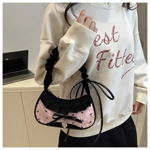 Détail du sac cabas en nylon rose avec motifs de nœuds noirs et bords volantés
