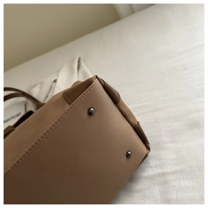 Dettaglio del fondo borsa tote in oxford con angoli rinforzati in pelle e piedini in metallo