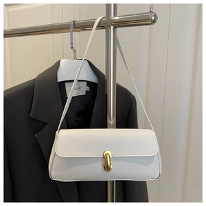 Detail of white lychee leather texture and golden U-shaped buckle on a baguette bag