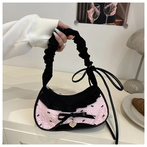 Vue détaillée du sac en jacquard rose avec nœuds noirs et pendentif en cœur