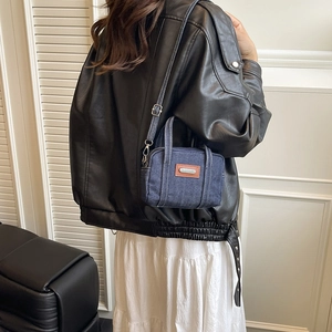 Mini dark blue denim crossbody bag with brown leather patches and white contrast stitching