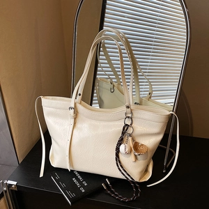 Chic off-white faux leather tote bag with baseball charm and textured surface