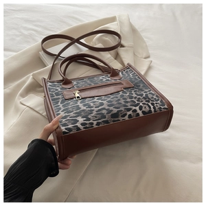 Dettaglio borsa a mano leopardata con finiture in pelle e cerniere dorate eleganti