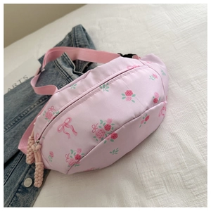 Detail of pink floral waist bag with rose print and woven rope zipper pull decoration