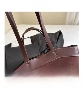 Detail view of dark brown tote bag with contrast stitching and premium mixed textures