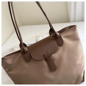 Dettaglio della borsa tote in nylon caffè con manici in pelle e fibbia decorativa