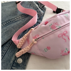 Close-up of pink floral fanny pack with rose prints and woven zipper detail